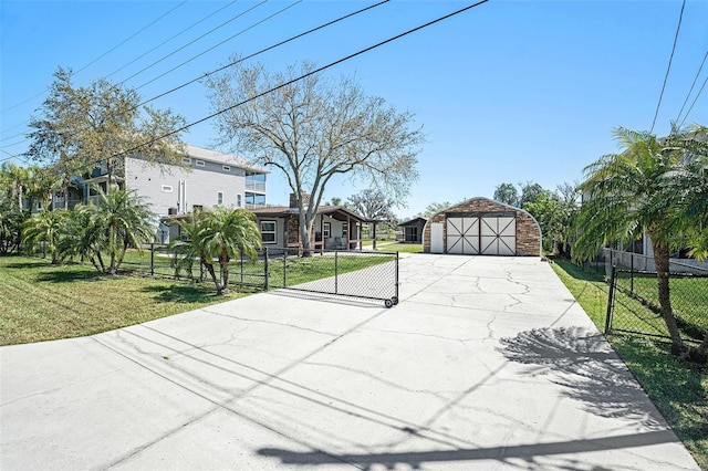 view of yard with a fenced front yard, an outbuilding, and a garage