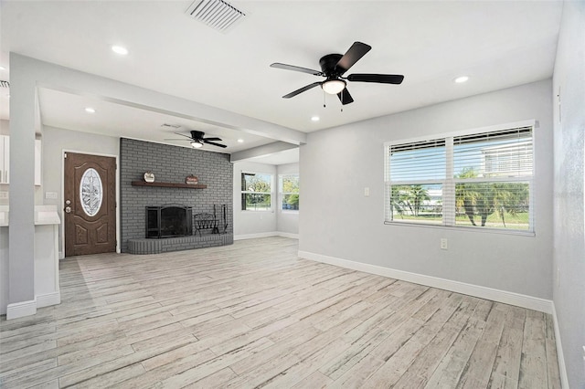 unfurnished living room featuring light wood finished floors, recessed lighting, a brick fireplace, and baseboards