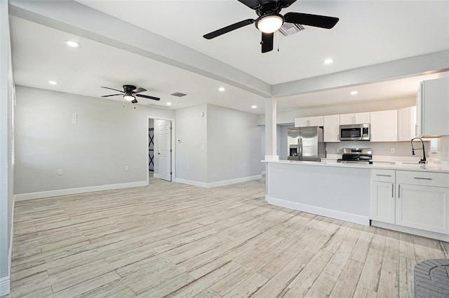 kitchen with visible vents, light wood finished floors, light countertops, appliances with stainless steel finishes, and open floor plan