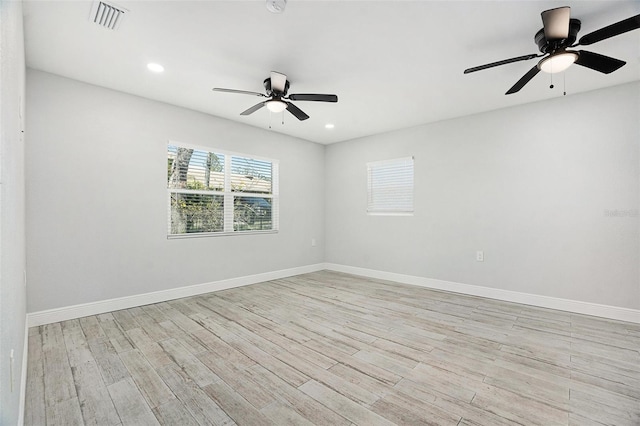 empty room featuring light wood finished floors, visible vents, recessed lighting, and baseboards