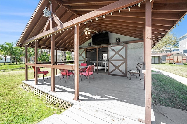 wooden terrace with a yard and ceiling fan