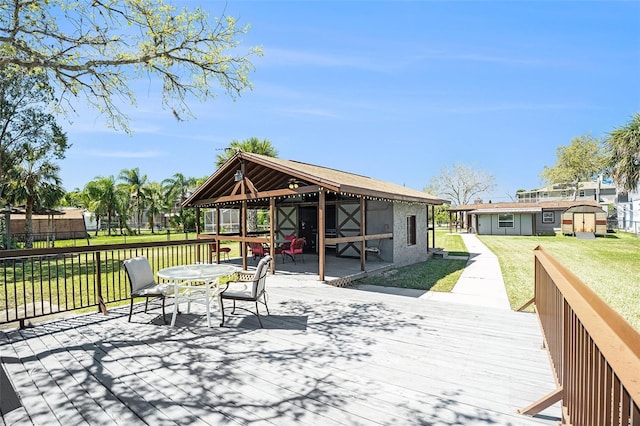 wooden deck with a gazebo, outdoor dining space, and a yard