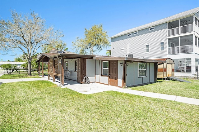 back of house featuring a lawn, a patio, and a ceiling fan