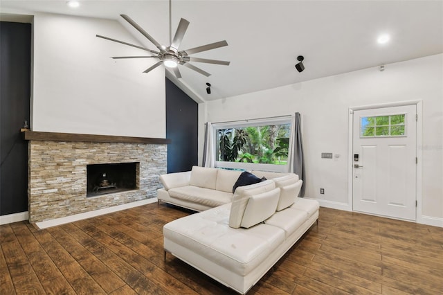 living area featuring a ceiling fan, hardwood / wood-style flooring, recessed lighting, a stone fireplace, and baseboards