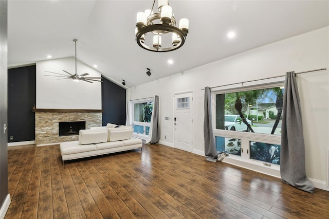 living room featuring hardwood / wood-style floors, baseboards, a fireplace, vaulted ceiling, and ceiling fan with notable chandelier