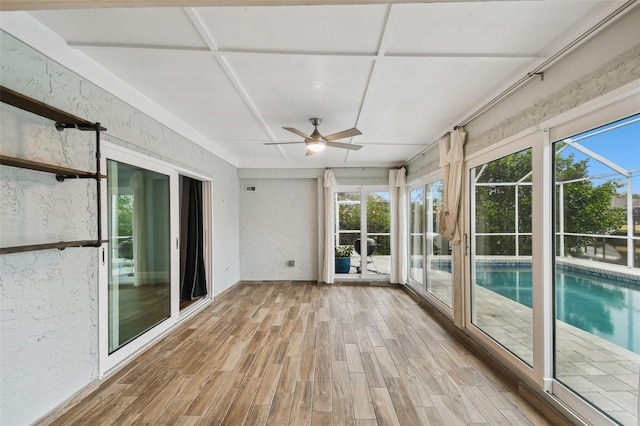 unfurnished sunroom with ceiling fan