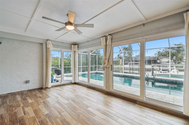 unfurnished sunroom featuring ceiling fan