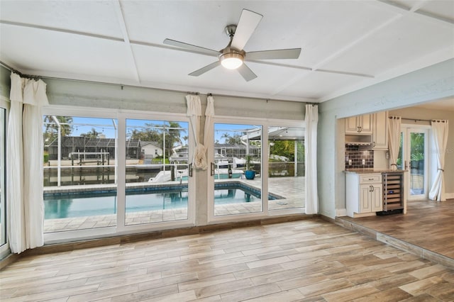 interior space with beverage cooler, light wood-style flooring, and ceiling fan