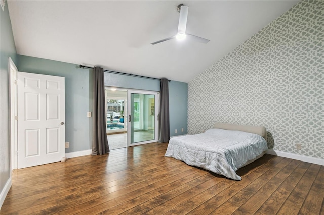 bedroom featuring baseboards, wallpapered walls, wood-type flooring, an accent wall, and access to outside