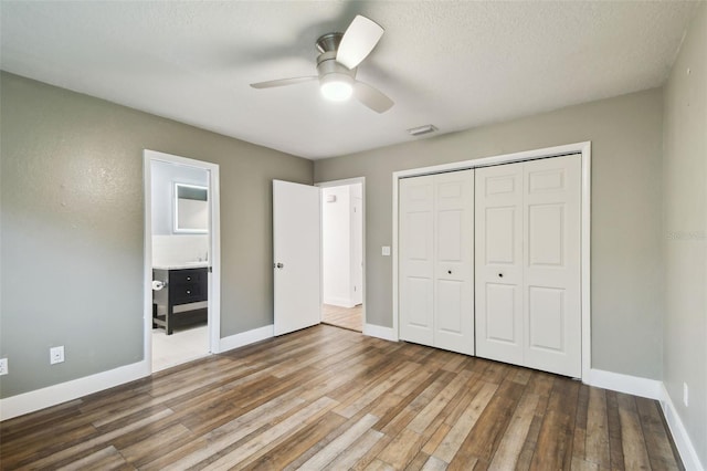 unfurnished bedroom with visible vents, baseboards, wood finished floors, a closet, and a ceiling fan