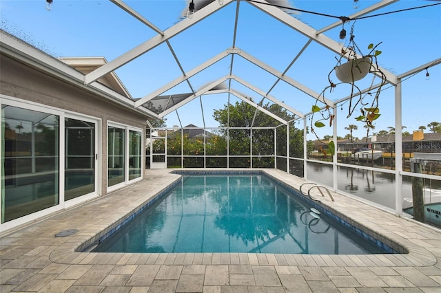 outdoor pool with a patio, a water view, and a lanai