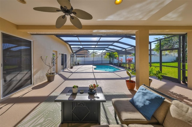 view of swimming pool with glass enclosure, fence, a fenced in pool, ceiling fan, and a patio area