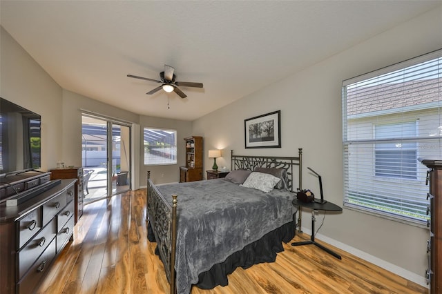 bedroom with ceiling fan, wood finished floors, baseboards, and access to outside