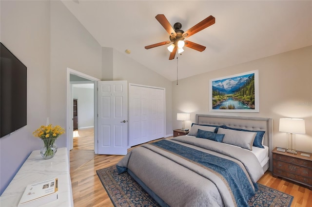 bedroom with a closet, lofted ceiling, a ceiling fan, and light wood finished floors