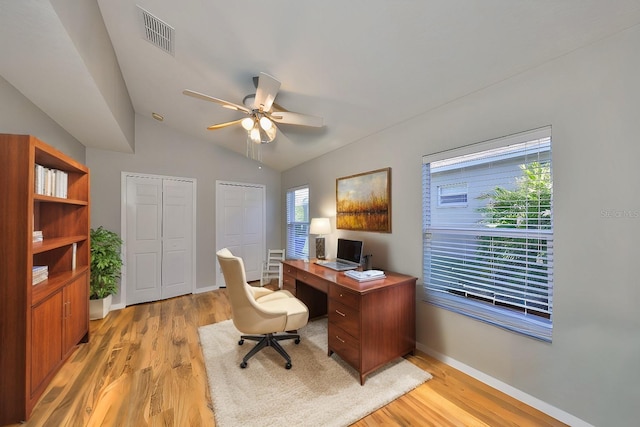 office area featuring visible vents, baseboards, light wood-type flooring, and lofted ceiling