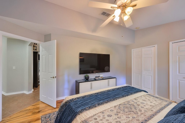 bedroom featuring visible vents, baseboards, a ceiling fan, and light wood finished floors