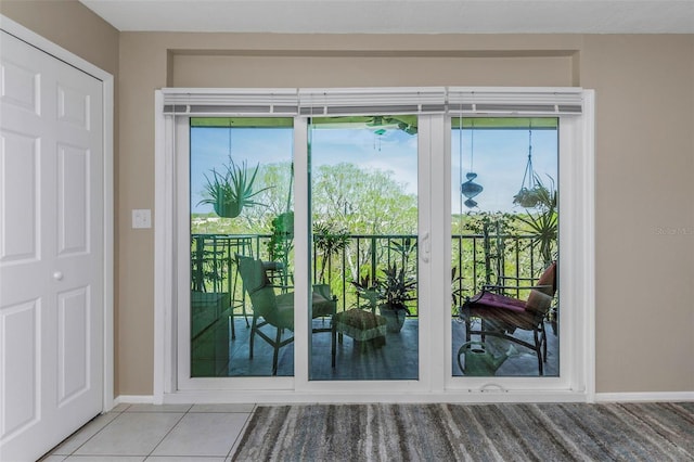 doorway to outside featuring tile patterned flooring and baseboards