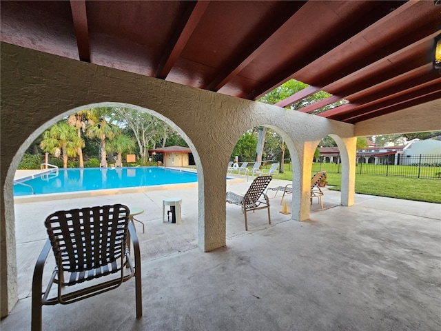 pool featuring a yard, a patio area, and fence