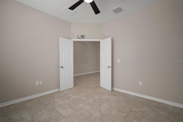 empty room with visible vents, baseboards, and a ceiling fan