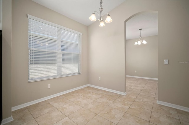 unfurnished room with light tile patterned floors, baseboards, arched walkways, vaulted ceiling, and a notable chandelier