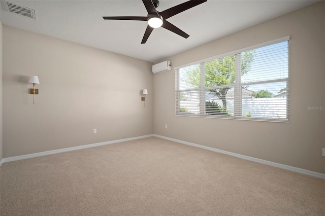 carpeted spare room featuring a ceiling fan, an AC wall unit, baseboards, and visible vents