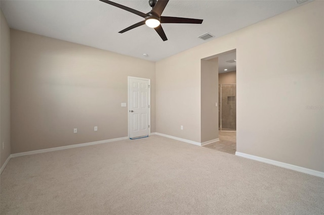 empty room featuring visible vents, light colored carpet, baseboards, and ceiling fan