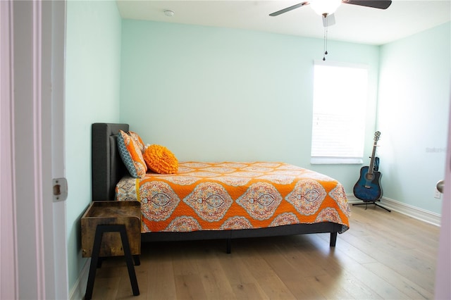 bedroom with baseboards, light wood-type flooring, and ceiling fan