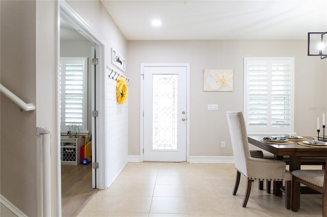 foyer entrance with light tile patterned floors, plenty of natural light, and baseboards