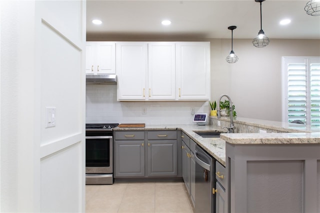 kitchen with a sink, decorative backsplash, gray cabinets, and stainless steel appliances