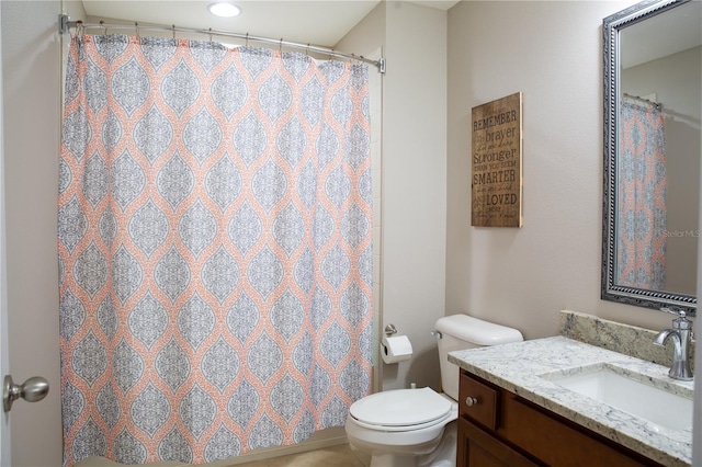 bathroom with vanity, curtained shower, and toilet