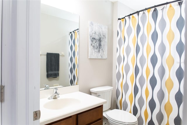 bathroom featuring toilet, vanity, and a shower with curtain