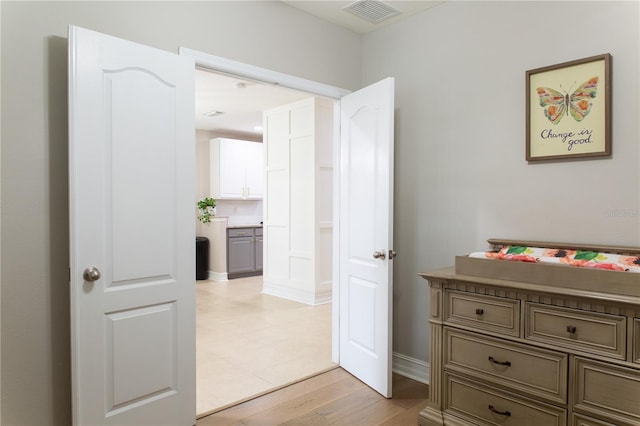 corridor with visible vents and light wood finished floors