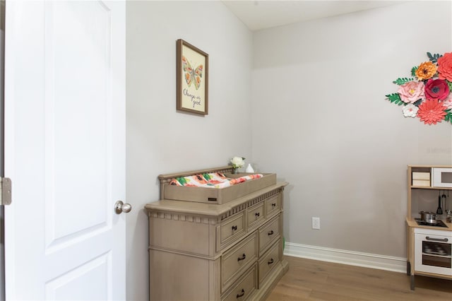 interior space featuring light wood-type flooring and baseboards