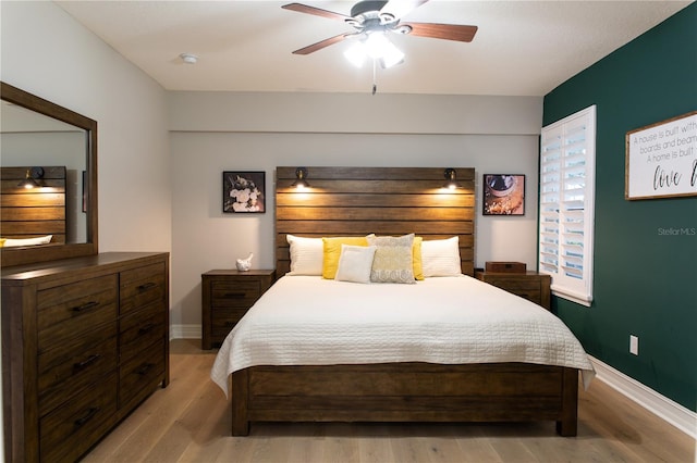 bedroom with ceiling fan, baseboards, and light wood-style floors