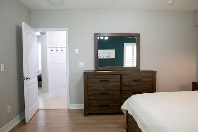 bedroom with visible vents, baseboards, and wood finished floors