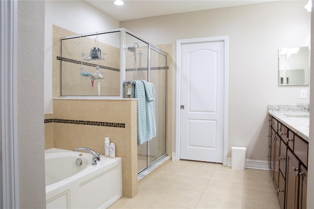 full bathroom featuring a stall shower, tile patterned flooring, baseboards, a bath, and vanity