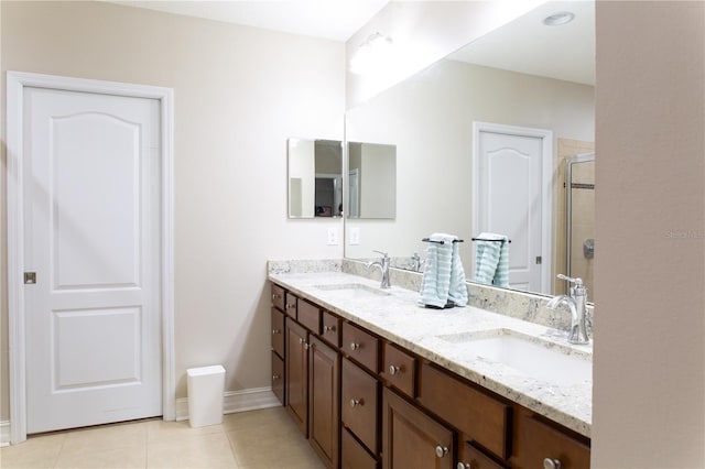 bathroom featuring tile patterned flooring, a shower stall, double vanity, and a sink