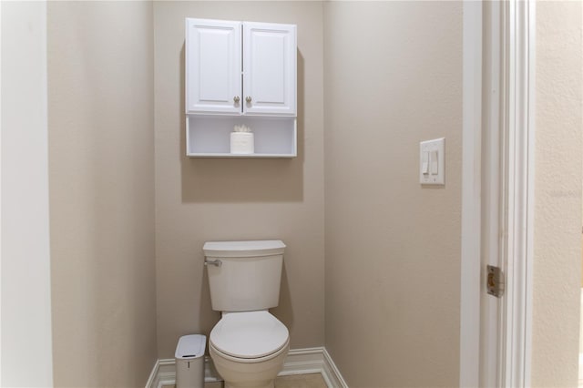 bathroom featuring toilet and baseboards