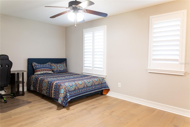 bedroom with baseboards, wood finished floors, and a ceiling fan