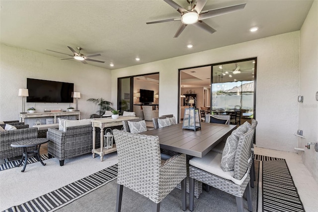 carpeted dining space featuring recessed lighting, a textured wall, and ceiling fan