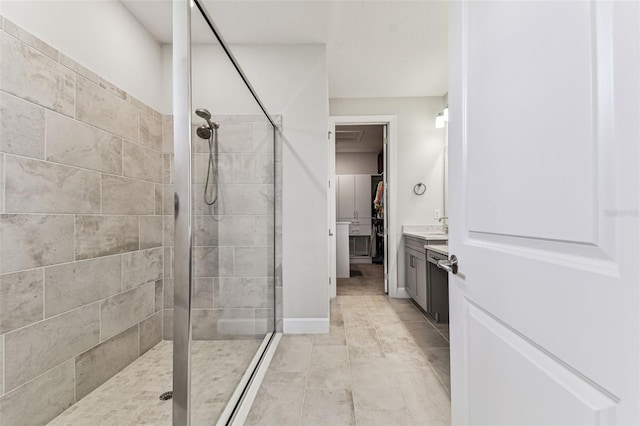 bathroom featuring tile patterned floors, a walk in closet, vanity, and a shower stall