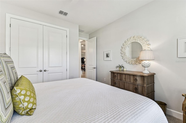 bedroom with a closet, baseboards, and visible vents