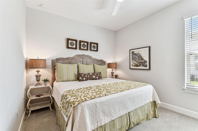 carpeted bedroom featuring multiple windows, baseboards, and ceiling fan