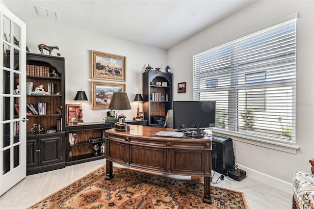 office space featuring visible vents, baseboards, and a textured ceiling