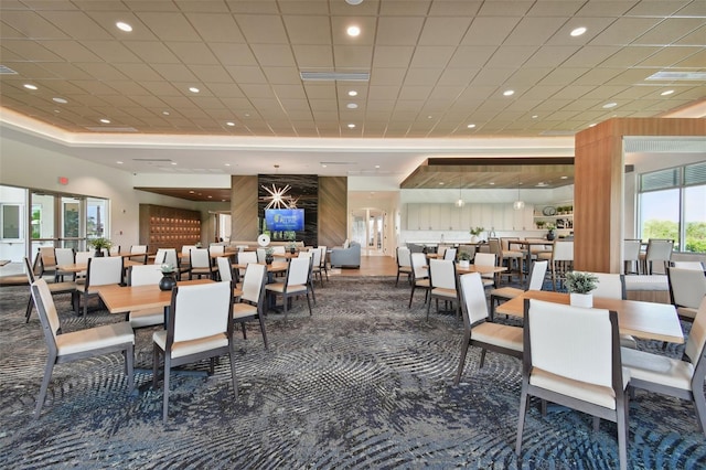 dining room featuring recessed lighting, a raised ceiling, and carpet