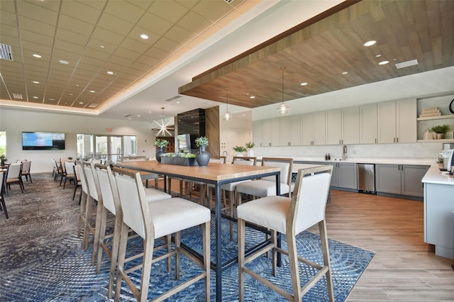 dining area featuring light wood-type flooring, visible vents, a tray ceiling, and recessed lighting