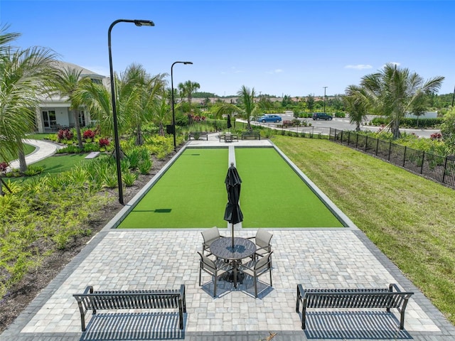 view of community featuring a yard and fence