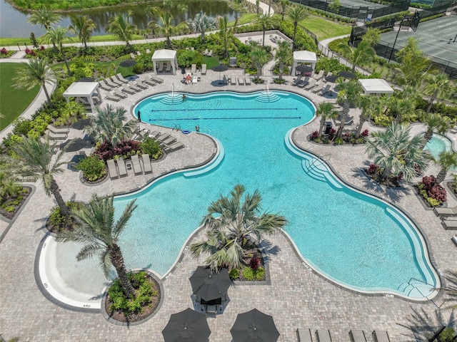 community pool with a gazebo, a patio, and a water view