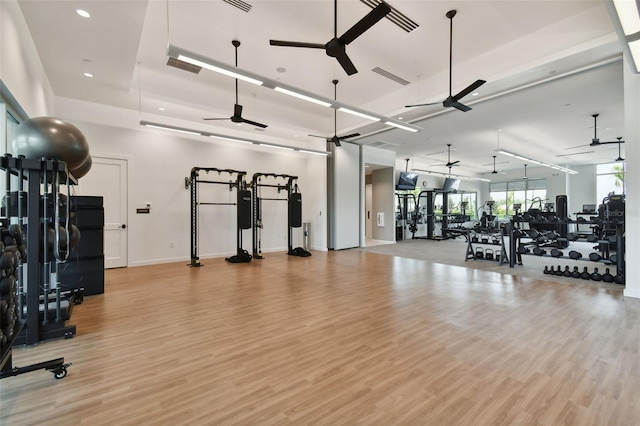 exercise room with visible vents, light wood-type flooring, and ceiling fan