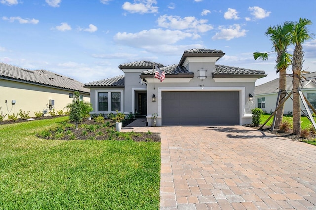 mediterranean / spanish-style home featuring a tiled roof, decorative driveway, a garage, and stucco siding